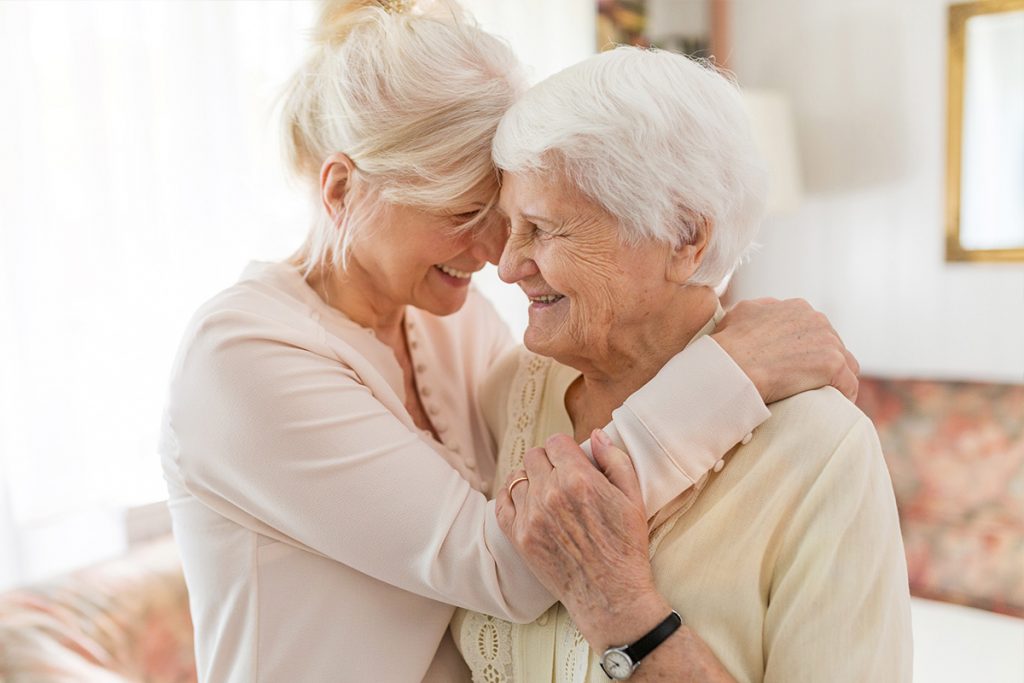 Two elderly ladies embrace in a heartwarming hug within the welcoming spaces of an Oakdale assisted living facility. Their genuine affection and connection capture the caring atmosphere and close-knit community fostered by the facility.