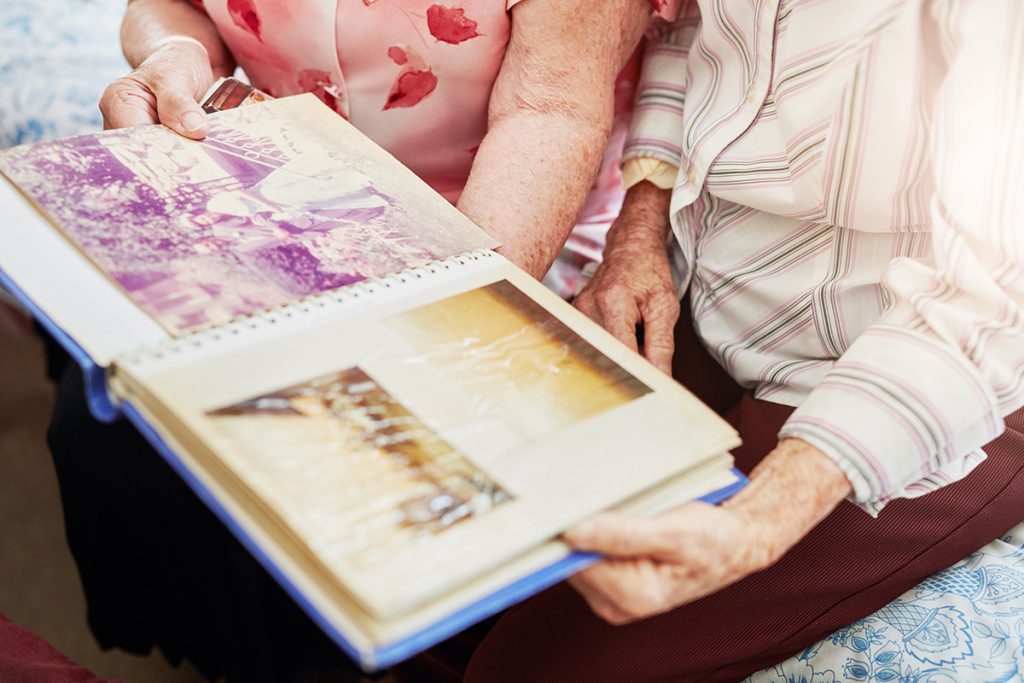 two elderly ladies looking at an album in a Modesto Assisted Living home