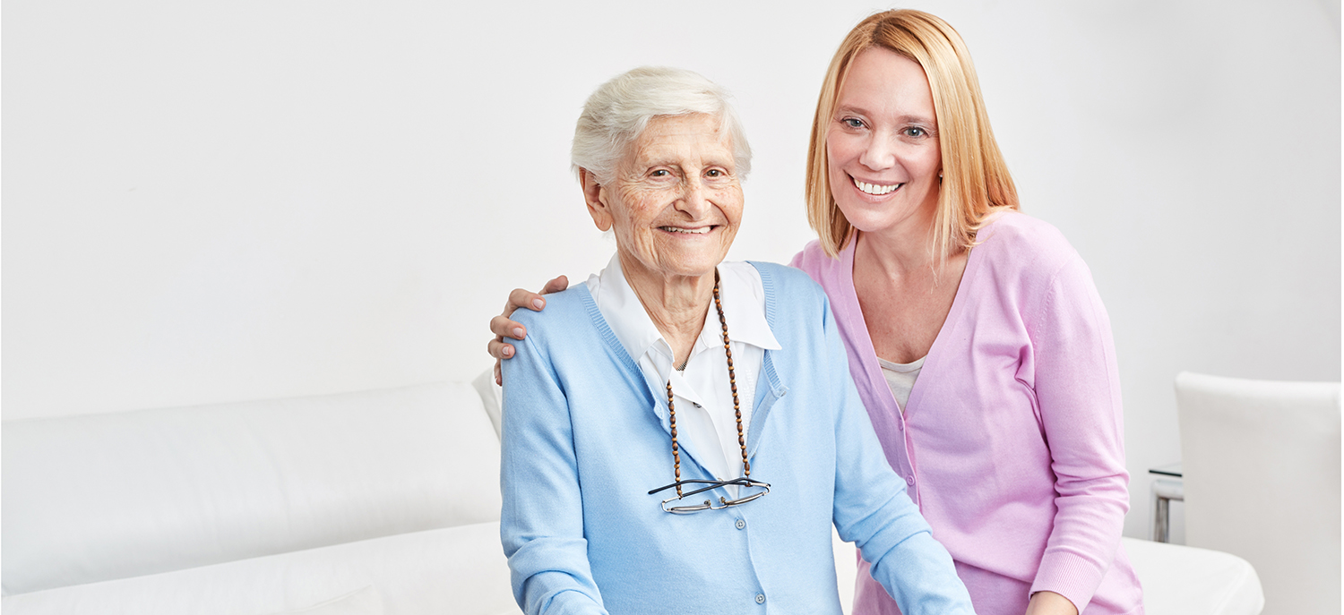 caregiver smiling next to a senior lady at an assisted living facility in Oakdale